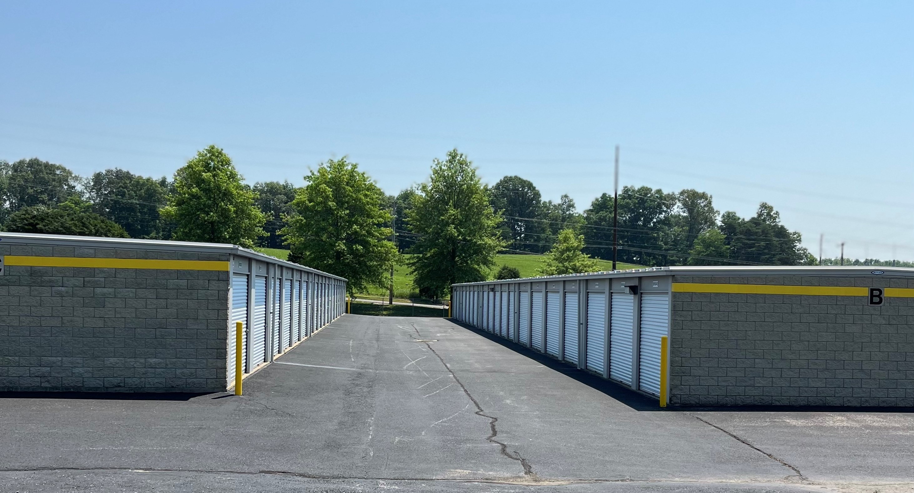 Drive-up storage units on Mill St, Jasper, offering wide driveways, white doors, diverse sizes, and a user-friendly kiosk.